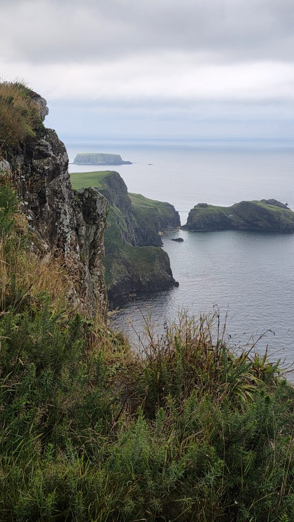 Dramatic green cliffs and rocky coastline overlooking the Atlantic near Carrick-a-Rede